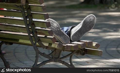 Feet of a person sleeping in a public park