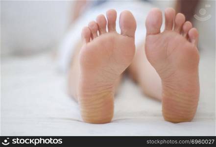 Feet of women sleeping on bed.. Woman feet on the bed
