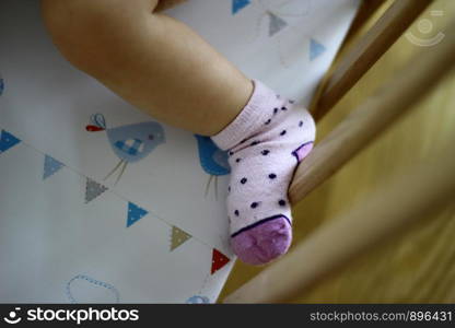 Feet of young child in a baby cot