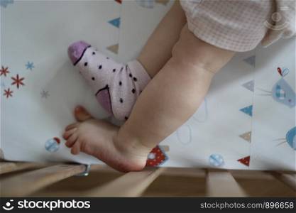 Feet of young child in a baby cot