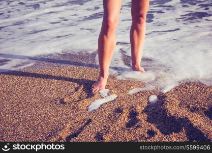 feet of young woman standing on beach