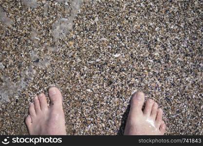 feet on the sand in the sea in summer
