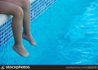 feet refreshing in swimming pool in summer
