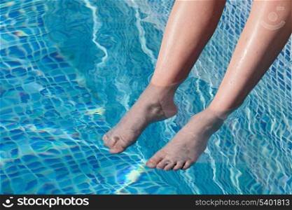 Feet refreshing in swimming pool in summer