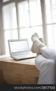 Feet up in loft apartment with laptop