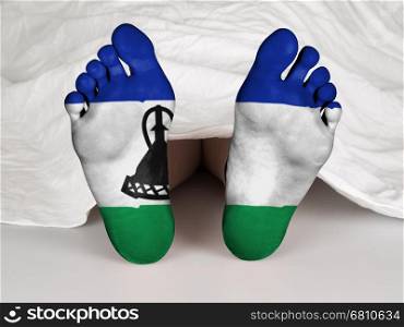 Feet with flag, sleeping or death concept, flag of Lesotho