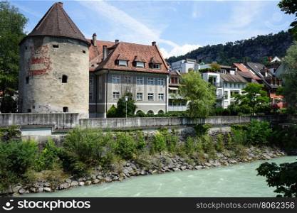 FELDKIRCH, AUSTRIA - CIRCA JULY 2016 Tower and house on the bank of river