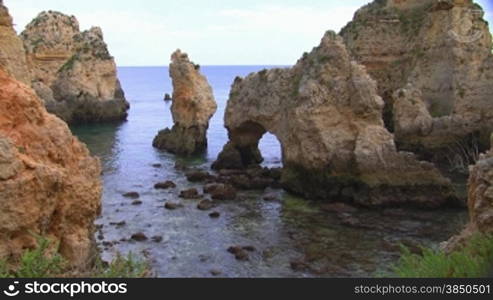 Felsengebilde im flachen Meer mit Steinen - Knste der Algarve, Portugal.