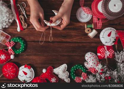 felt Christmas decorations on the wooden table - woman is preparing for handmade. felt Christmas decorations