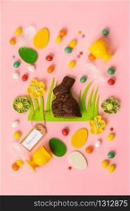 Felt Easter decorations and sweets on pink background, flat lay, top view