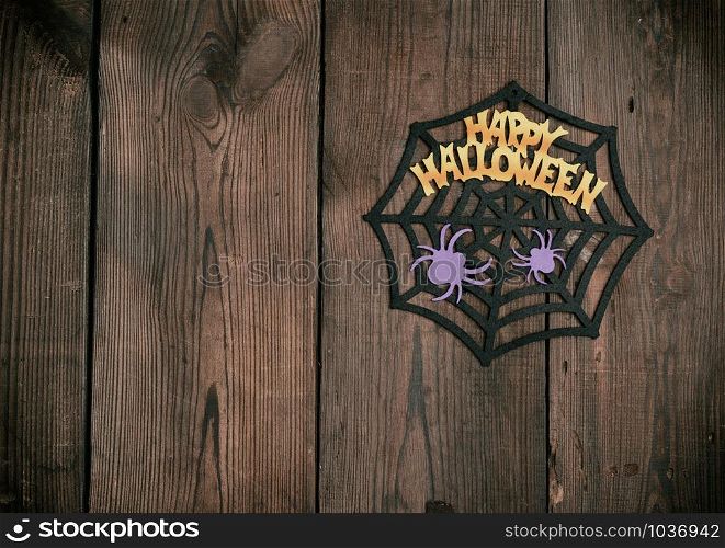 felt figures of the web, spider for the holiday of Halloween on a brown background, top view
