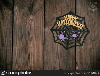 felt figures of the web, spider for the holiday of Halloween on a brown background, top view