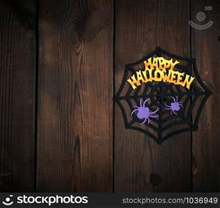 felt figures of the web, spider for the holiday of Halloween on a brown background, top view, copy space