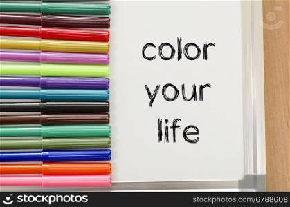 Felt-tip pen and whiteboard on a wooden background and color your life text concept