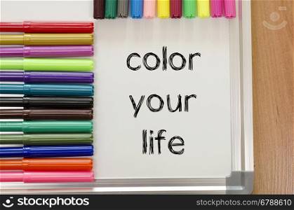 Felt-tip pen and whiteboard on a wooden background and color your life text concept
