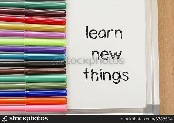 Felt-tip pen and whiteboard on a wooden background and learn new things text concept