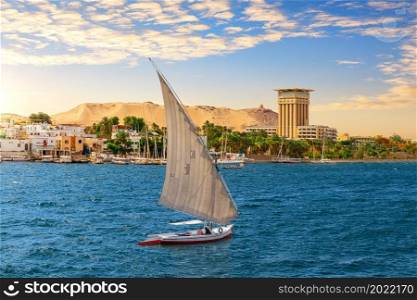 Felucca in the blue waters of Nile, Aswan city, Egypt.. Felucca in the blue waters of Nile, Aswan city, Egypt
