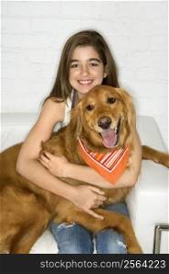 Female adolescent Caucasian holding Golden Retriever dog.