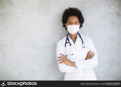 Female African American doctor wear white uniform and protective face mask in the hospital