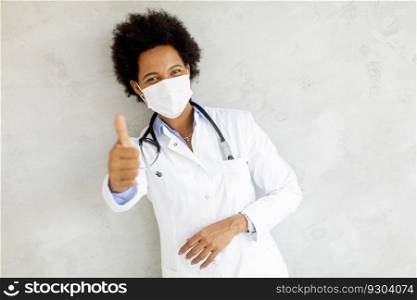 Female African American doctor wear white uniform and protective facial mask in the hospital