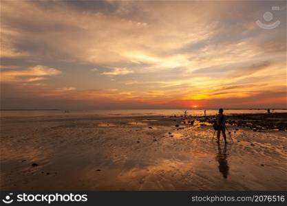 female amateur photographer Taking sunset pictures on the beach in twilight time