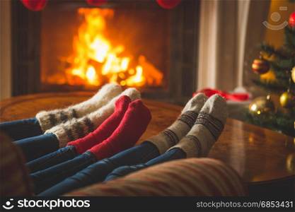 Female and male feet in wool socks warming at fireplace at chalet
