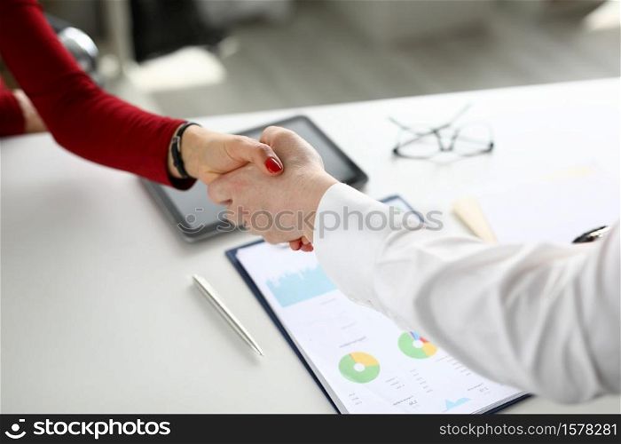 Female and male handshake in office. Business arrangement concept. Female and male handshake in office closeup