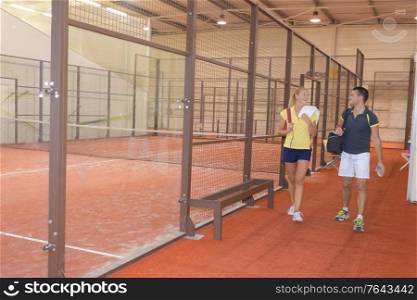 female and male legs at indoor tennis court