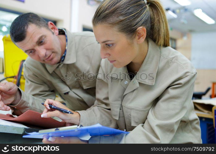 female apprentice comparing notes to file