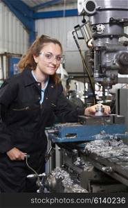 Female Apprentice Engineer Working On Drill In Factory