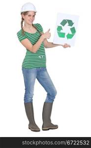 female apprentice holding recycling logo