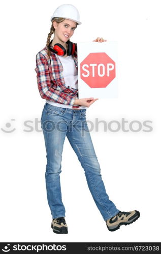 female apprentice holding stop sign