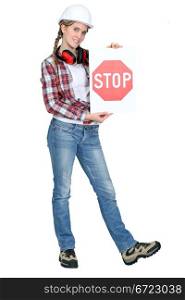 female apprentice holding stop sign