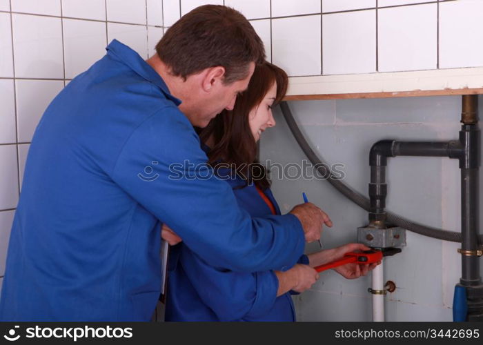 female apprentice plumber and male instructor