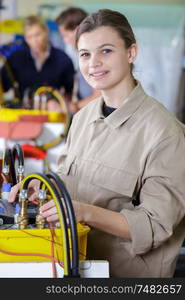 female apprentice working in electronic factory