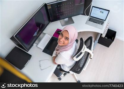 Female Arabic creative professional working at the home office on a desktop computer with dual screen monitor top view. Selective focus. High quality photo. Female Arabic creative professional working at home office on desktop computer with dual screen monitor top view. Selectve focus