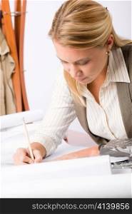 Female architect attractive working on a blueprint sketches in office