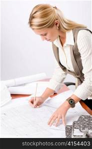 Female architect attractive working on a blueprint sketches in office