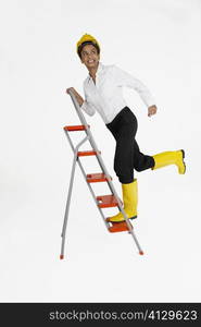 Female architect climbing a ladder and smiling