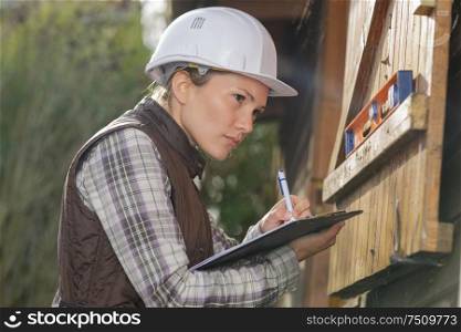 female architect inspecting wooden house