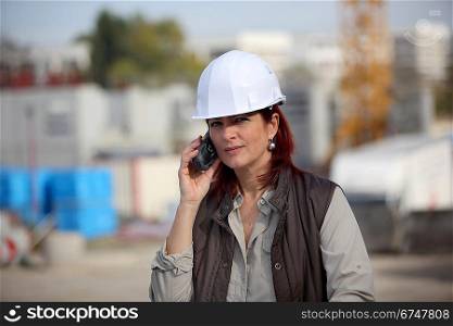 female architect making a call in construction site