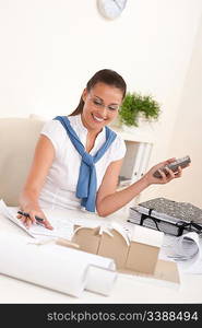 Female architect with phone sitting at the office