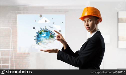 Female architect woman. Engineer woman in helmet and Earth planet in her palm. Elements of this image are furnished by NASA