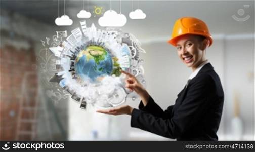 Female architect woman. Engineer woman in helmet and Earth planet in her palm. Elements of this image are furnished by NASA