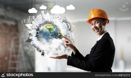 Female architect woman. Engineer woman in helmet and Earth planet in her palm. Elements of this image are furnished by NASA