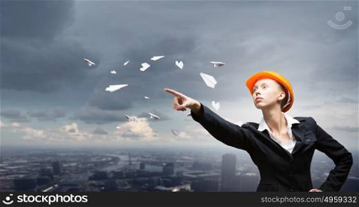Female architect woman. Woman in helmet and paper airplanes flying around