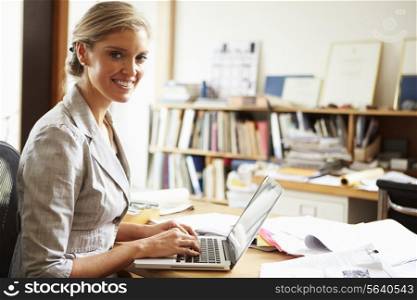 Female Architect Working At Desk On Laptop
