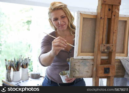 Female Artist Painting In Studio