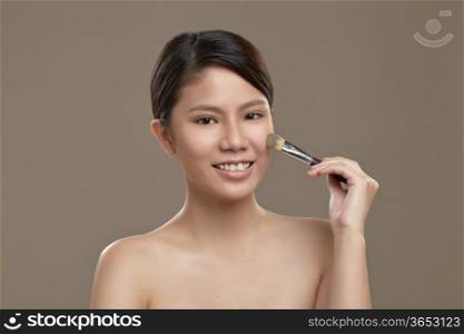 Female asian applying foundation
