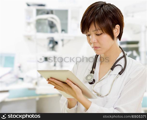 Female Asian doctor using tablet computer in clinic lab